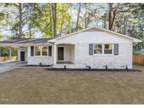 Charming brick home featuring a covered carport and black-shuttered windows at 3907 Inwood Dr, Durham, NC 27705