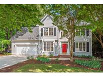 Charming two-story home with a well-manicured lawn and a bright red front door at 4900 American Dr, Durham, NC 27705