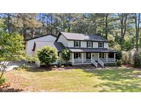 Charming two-story home featuring a welcoming front porch and a well-manicured lawn surrounded by mature trees at 512 Stratford Dr, Zebulon, NC 27597