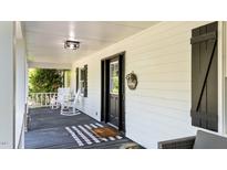 Inviting front porch featuring rocking chairs and a welcoming entrance with a stylish rug at 512 Stratford Dr, Zebulon, NC 27597