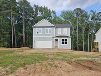 Charming two-story home with attached garage and light blue siding, surrounded by mature trees at 629 Conover Rd, Durham, NC 27703