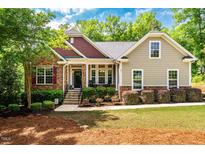 Charming home with a well-maintained lawn, stone accents, and inviting front porch at 67 Crimson Way, Pittsboro, NC 27312