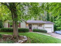 Charming home featuring mature trees, lush landscaping, covered front porch, and inviting curb appeal at 6820 Chamonix Pl, Raleigh, NC 27613