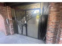 Brick entrance gate with artistic metalwork and concrete stairs, blending security with design at 807 W Trinity Ave # 144, Durham, NC 27701