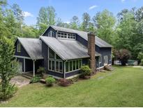 Two-story home with a brick chimney, garage, and well-maintained lawn at 1000 Phils Creek Rd, Chapel Hill, NC 27516