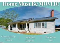 Charming single story home featuring a covered front porch and an attached carport at 107 N Pearl St, Princeton, NC 27569
