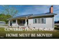 Charming single-story home featuring a welcoming covered front porch, complemented by green shutters and a well-maintained lawn at 107 N Pearl St, Princeton, NC 27569