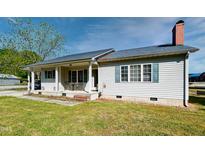 Charming single-story home with a cozy front porch, brick chimney, and manicured lawn at 107 N Pearl St, Princeton, NC 27569