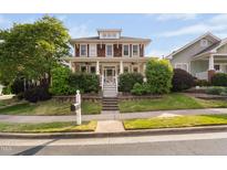 Charming two-story home with a welcoming front porch and professionally landscaped front yard at 112 Homegate Cir, Apex, NC 27502