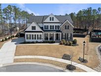 Stunning two-story home featuring a combination of white siding and brick, with a well-manicured lawn at 113 Amberwing Ct, Holly Springs, NC 27540