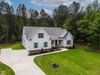 Charming two-story home with light blue siding, green shutters, manicured landscaping, and a spacious driveway at 1218 Red Cedar Ct, Youngsville, NC 27596