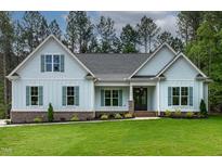 Charming single-story home featuring light blue siding, a gray roof, and lush green lawn at 1218 Red Cedar Ct, Youngsville, NC 27596