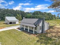 Charming home with a front porch, detached garage, and a well-manicured lawn at 1347 Crocker Rd, Smithfield, NC 27577