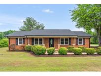 Charming brick home with a covered front porch and mature landscaping at 1647 Turner Rd, Mebane, NC 27302