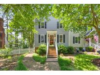 Charming two-story home featuring gray siding, black shutters, a red front door, and a welcoming front yard at 1806 Carrington Dr, Raleigh, NC 27615