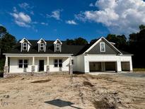 New construction home featuring a two-car garage and dormer windows under a cloudy sky at 196 Cozy Brook Ct, Clayton, NC 27520