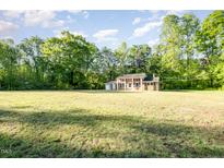 Traditional brick home with a large front yard and mature trees under a sunny sky at 2027 Jefferson Dr, Hillsborough, NC 27278