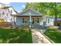 Charming blue home featuring a covered front porch with rocking chairs and manicured lawn at 2210 Bedford Ave, Raleigh, NC 27607