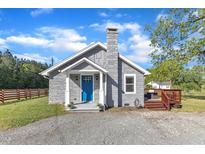 Charming home featuring a stone facade, blue front door, stone chimney, and a well-maintained gravel driveway at 2501 Ferrell Rd, Durham, NC 27704