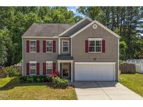Charming two-story home boasts red shutters, a well-maintained lawn, and an attached two car garage at 3069 Buttonwood Ln, Clayton, NC 27520