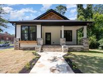 Inviting home with a stone walkway, porch with stone accents, and manicured lawn at 310 W Club Blvd, Durham, NC 27704