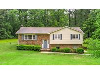 Charming split-level home with a brick facade and manicured lawn surrounded by mature trees at 4006 Daniel Rd, Durham, NC 27703