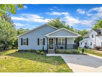 Charming home featuring a welcoming front porch, fresh landscaping, and a well-manicured lawn at 407 Collier St, Smithfield, NC 27577