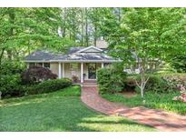 Charming home featuring a brick walkway, covered front porch, and lush landscaping at 415 Forsyth St, Raleigh, NC 27609