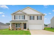 Charming two-story home with a well-manicured lawn, stone accents, and a two-car garage at 506 Lochalsh Dr, Gibsonville, NC 27249