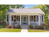 Charming home featuring a welcoming front porch with hanging plants and a well-maintained landscaped yard at 518 S Main St, Wake Forest, NC 27587