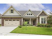 Charming single-Gathering home featuring brick accents, a well-manicured lawn, and a welcoming front porch at 624 Meadowgrass Ln, Wake Forest, NC 27587