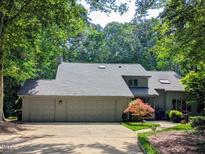 Charming home featuring an attached three-car garage and lush landscaping creating a serene and inviting curb appeal at 10044 Old Warden Rd, Raleigh, NC 27615