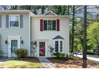 Charming townhome with white siding, red shutters, and well-manicured landscaping at 102 Rosebrooks Dr, Cary, NC 27513