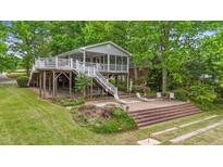 Charming lake house featuring a screened porch, spacious deck, and a brick patio at 104 Pontiac Cv, Louisburg, NC 27549