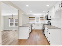 Modern farmhouse style kitchen featuring white cabinets, hardwood floors, and stainless steel appliances at 105 N 11Th St, Erwin, NC 28339