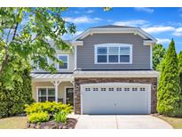 Charming two-story home features a stone facade and well-manicured landscaping, enhancing curb appeal at 120 Cobblebrook Ct, Holly Springs, NC 27540