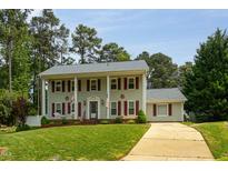 Charming two-story home with red shutters, pillars, manicured lawn, and a paved driveway at 1213 Indian Trail Dr, Raleigh, NC 27609