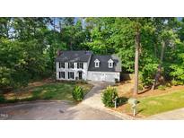 Charming two-story home with black shutters, manicured lawn, and an attached two-car garage at 1609 Falls Ct, Raleigh, NC 27615