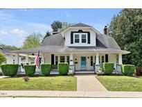Charming home with a covered front porch, manicured lawn, and classic architectural details at 310 Henderson St, Oxford, NC 27565