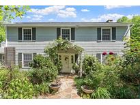 Charming two-story home with mature landscaping and a welcoming stone walkway to the front door at 400 Bowling Creek Rd, Chapel Hill, NC 27514