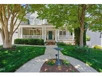 Charming home featuring a welcoming front porch, lush lawn, and mature trees at 415 Waverly Hills Dr, Cary, NC 27519