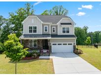Charming two-story home featuring stone accents, a covered porch, a well-manicured lawn, and an attached two-car garage at 46 Waterfall Pointe, Chapel Hill, NC 27517