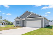 Charming single-Gathering home features a two-car garage, gray siding, and well-manicured lawn at 514 Lochalsh Dr, Gibsonville, NC 27249
