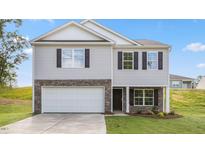 Two-story home features stone accents, a two-car garage, and professional landscaping at 522 Lochalsh Dr, Gibsonville, NC 27249