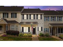 Charming townhome featuring gray siding, black shutters, a cozy front porch, and an American flag at 831 S White St, Wake Forest, NC 27587