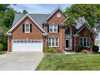Stately brick home featuring manicured lawn, two car garage, and classic architectural details at 105 Bardsey Ct, Cary, NC 27513