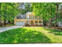 Charming two-story home with a well-manicured lawn, attached garage, and inviting front porch at 11 Bridgeport Dr, Durham, NC 27713