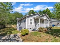 Charming home featuring gray siding, white trim, inviting front porch and partially shaded yard at 1112 Mark St, Raleigh, NC 27601