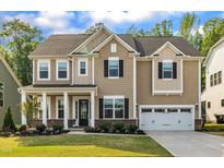 Charming two-story home with a well-manicured lawn, covered porch and attached two car garage at 112 Serenata Dr, Holly Springs, NC 27540