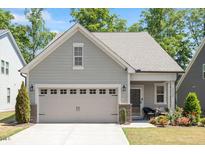 Charming home with a gray exterior, two car garage, and beautifully landscaped front yard at 12404 Huntley Chase Dr, Durham, NC 27703